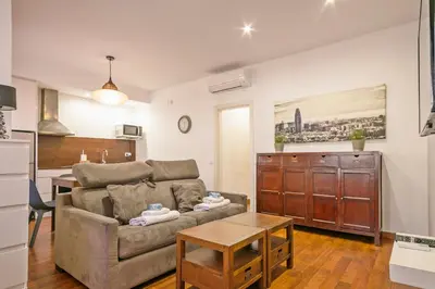 a living room with a couch and a kitchen at Alcam Enamorats in Barcelona