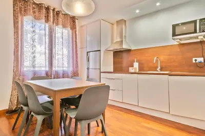 a kitchen with a dining room table and chairs at Alcam Enamorats in Barcelona