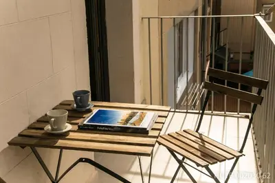a table with a book and two cups and a chair at Alcam Molino in Barcelona