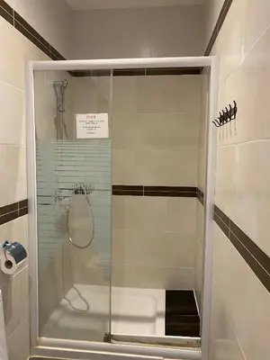 a shower with a glass door in a bathroom at Hostal Granvia 628 in Barcelona