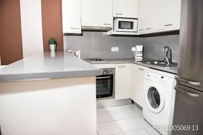 a white kitchen with a sink and a dishwasher at Alcam Aribau in Barcelona