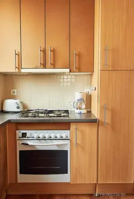 a kitchen with a stove and wooden cabinets at Alcam Rizal in Barcelona