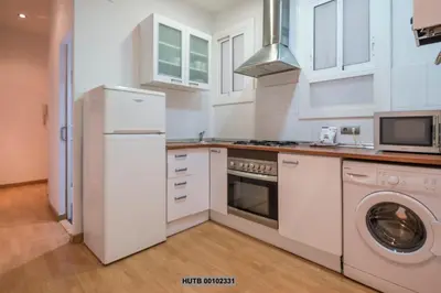 a kitchen with white appliances and a washer and dryer at Alcam Montjuic in Barcelona
