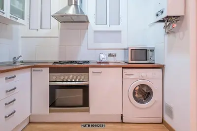 a kitchen with a washing machine and a microwave at Alcam Montjuic in Barcelona