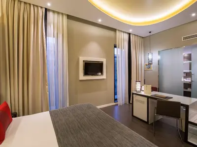 a bedroom with a bed and a desk and a tv at Vincci Gala in Barcelona