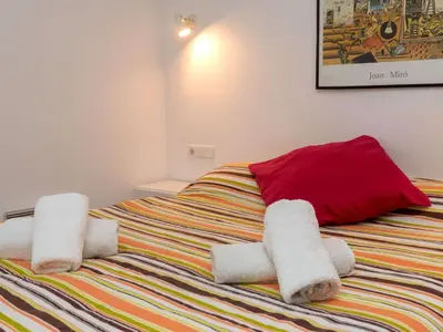 a bedroom with a bed with towels on it at Apartment Primer de Maig by Interhome in Sitges