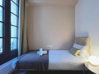 a small bedroom with a bed and a window at Stay U-nique Apartments Vila de Gracia in Barcelona