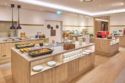 a buffet in a restaurant with food on display at Hampton By Hilton Barcelona Fira Gran Via in Hospitalet de Llobregat
