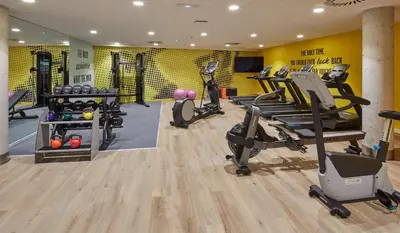 a gym with treadmills and exercise bikes in a room at Hampton By Hilton Barcelona Fira Gran Via in Hospitalet de Llobregat