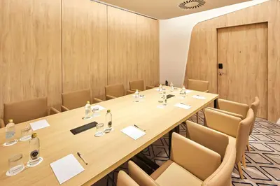 a conference room with a large wooden table and chairs at Hampton By Hilton Barcelona Fira Gran Via in Hospitalet de Llobregat