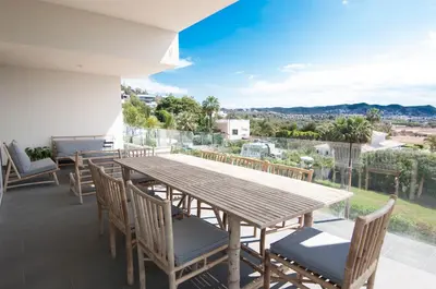 a wooden table and chairs on a balcony with a view at Villa Miramar by Glasir in Sitges