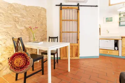 a dining room with a white table and chairs at Apartamento rústico reformado con encanto (Garraf) in Sant Pere de Ribes