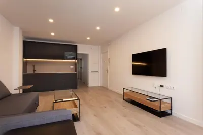a living room with a couch and a tv on a wall at Rambla Catalunya 8 in Barcelona