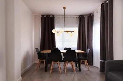 a dining room table with black chairs and a chandelier at Rambla Catalunya 8 in Barcelona