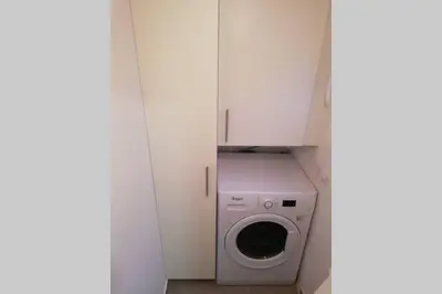 a small laundry room with a washer and dryer at M1 Cool Loft 1 min walk to metro 15 min center by metro in Esplugues de Llobregat