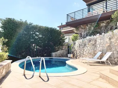 a swimming pool with two chairs next to a house at Sitges Spaces Sea View Villa- 6 Bedrooms, 5 bathrooms, 2 private pools, Near center in Sitges