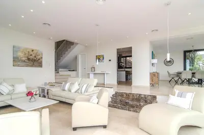 a living room with white furniture and a staircase at Sitges Spaces Sea View Villa- 6 Bedrooms, 5 bathrooms, 2 private pools, Near center in Sitges