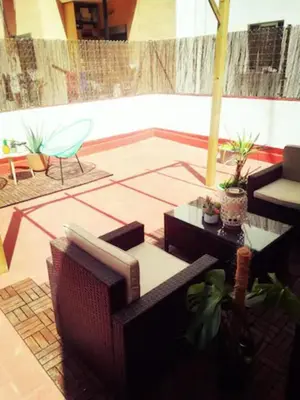 a patio with a couch and tables and a chair at M2 Cool apartment next to metro. 15m to center in Esplugues de Llobregat
