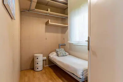 a small bedroom with a bed and a window at 731 - AB Enric Granados Apartment in Barcelona