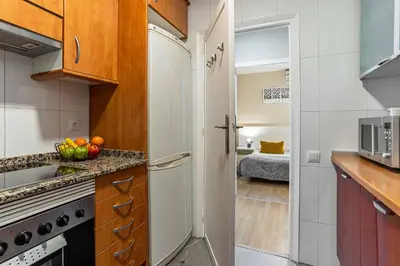 a kitchen with a white refrigerator and a sink at 731 - AB Enric Granados Apartment in Barcelona