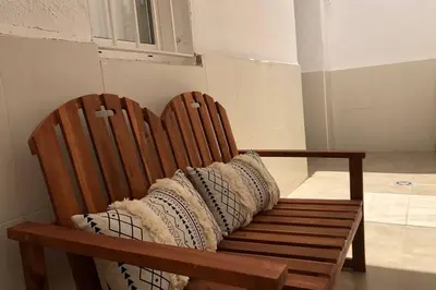 a wooden bench with pillows on it in a room at M3 Terrace. Cool apartment 15 min center by metro in Esplugues de Llobregat