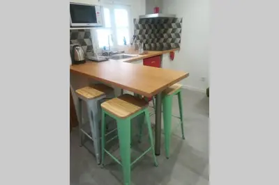 a kitchen with a wooden table and stools at M3 Terrace. Cool apartment 15 min center by metro in Esplugues de Llobregat