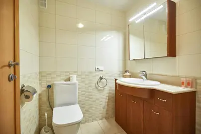 a bathroom with a toilet and a sink and a mirror at BBarcelona Marina Flat in Barcelona