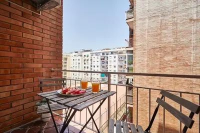 a table with a plate of fruit on a balcony at BBarcelona Marina Flat in Barcelona