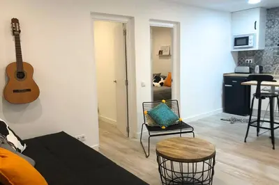 a living room with a guitar hanging on the wall at M5 Cool Terrace. Metro 1 min. Center 15' by metro in Esplugues de Llobregat