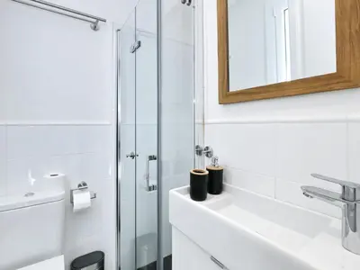 a white bathroom with a sink and a shower at Casa nanit apt a in Hospitalet de Llobregat