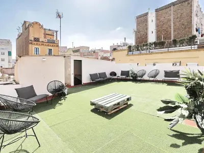 a rooftop patio with chairs and a table on a building at Casa nanit apt c in Hospitalet de Llobregat
