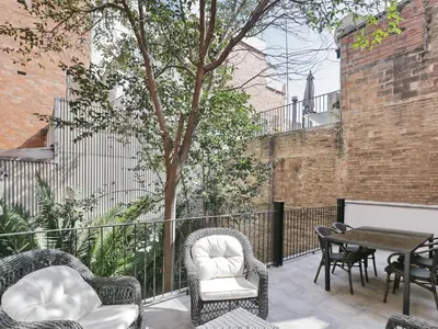 a patio with chairs and a table and a tree at Casa nanit apt c in Hospitalet de Llobregat