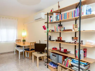 a room with a desk and a shelf with books at Apartment Camp Nou by Interhome in Barcelona