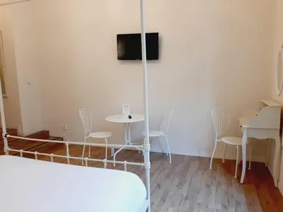 a room with a bed and a table and chairs at Lumine Luxury Suites by gaiarooms in Barcelona