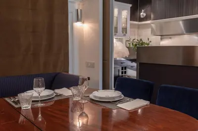 a dining room table with plates and wine glasses at SuiteaBcn II in Barcelona
