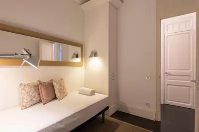 a room with a bed with a mirror and a door at SuiteaBcn II in Barcelona