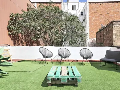 a patio with chairs and a bench and a table at Casa nanit apt b in Hospitalet de Llobregat