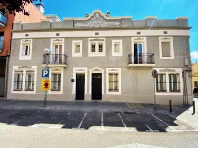 a large white building with a parking lot in front of it at Casa nanit apt b in Hospitalet de Llobregat