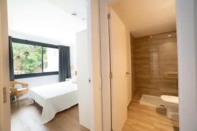 a bathroom with a bed and a toilet in a room at Apartaments Voralmar in Caldes d'Estrac