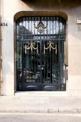 a black door on a building with curtains on it at Casa Valeta in Barcelona