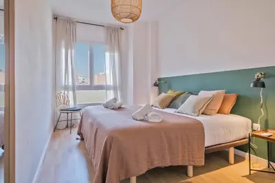 a bedroom with a large bed with a green headboard at Habitat Apartments Plaza España Urban in Barcelona