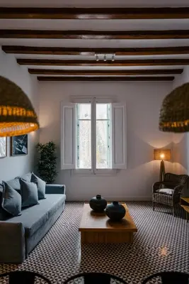 a living room with a blue couch and a table at 1840 Apartments Sitges by Suma Hotels in Sitges