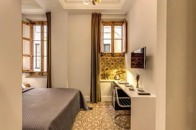 a bedroom with a bed and a desk and windows at We Boutique Hotel Barcelona in Barcelona
