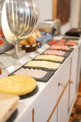 a counter top with cheese and other foods on it at We Boutique Hotel Barcelona in Barcelona