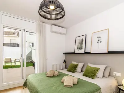 a bedroom with a large bed with green sheets at Sitges Spaces Terrace Apartment- 1 Bedroom, 1Bathroom, Huge Terrace in Sitges