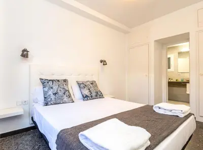 a white bedroom with a large white bed at Find Calm at this cozy City Sanctuary with terrace in Barcelona