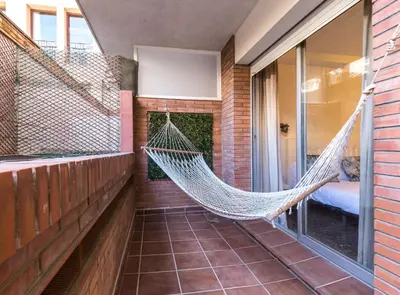 a hammock hanging on the side of a house at Find Calm at this cozy City Sanctuary with terrace in Barcelona