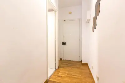 a hallway with a white door and a wooden floor at Find Calm at this cozy City Sanctuary with terrace in Barcelona