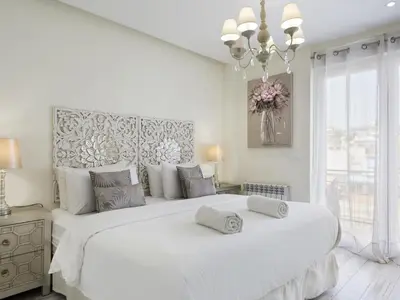 a white bedroom with a large white bed and a chandelier at Sitges Spaces Mediterranean Apartments 5 Bedrooms, 4 Bathrooms, 75M2 Terrace, Centre Sitges- Sleeps 11 in Sitges