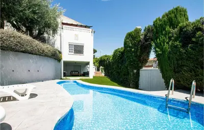 a swimming pool in front of a house with trees at 5 Bedroom Awesome Home In Alella in Alella